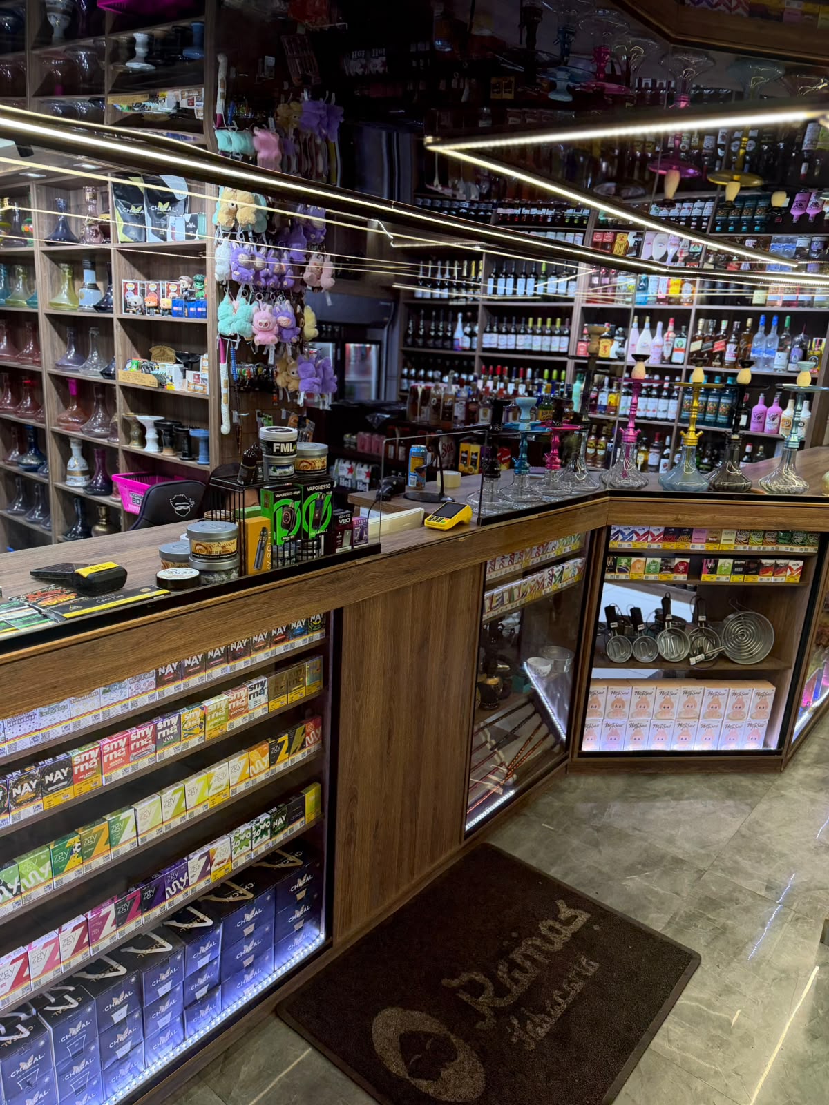 Balcão da tabacaria com cigarros, vapes e narguilés